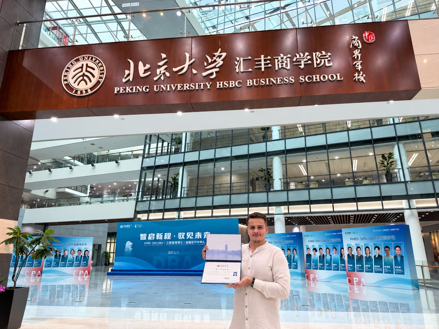 Bartosz z dyplomem w atrium Peking University HSBC Business School